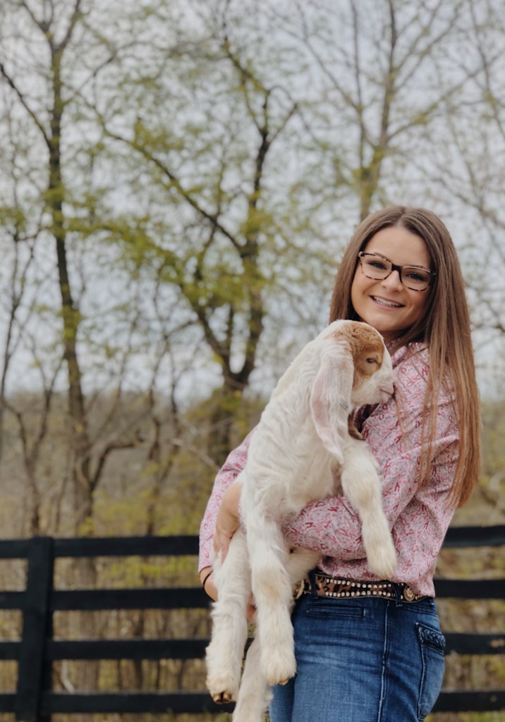 Girl holding baby goat 